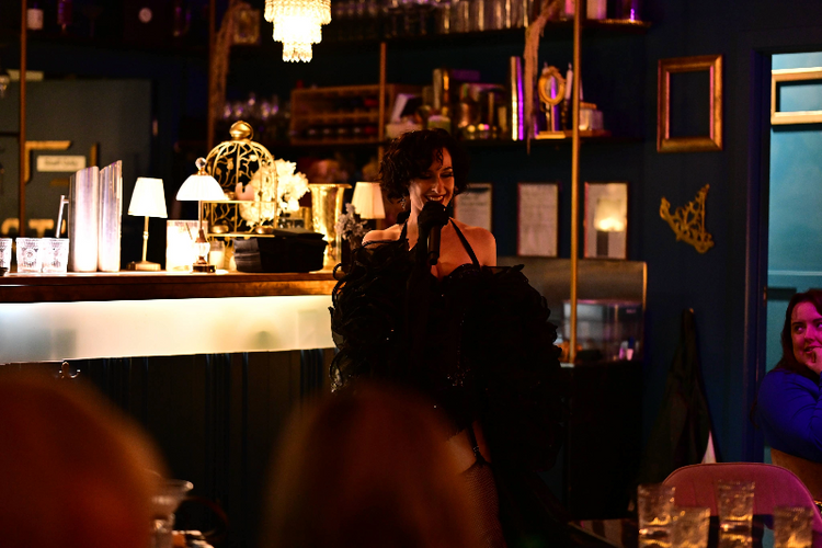 Aces Bar setting with patrons and a bartender in a dimly lit room