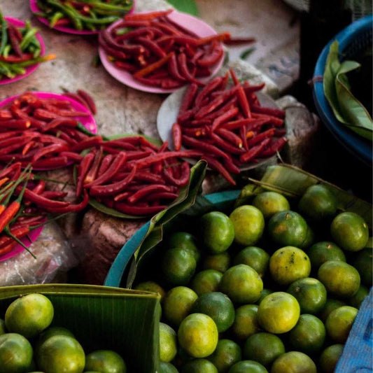 limes chillis and kaffir lime leaves on market table in South East Asia